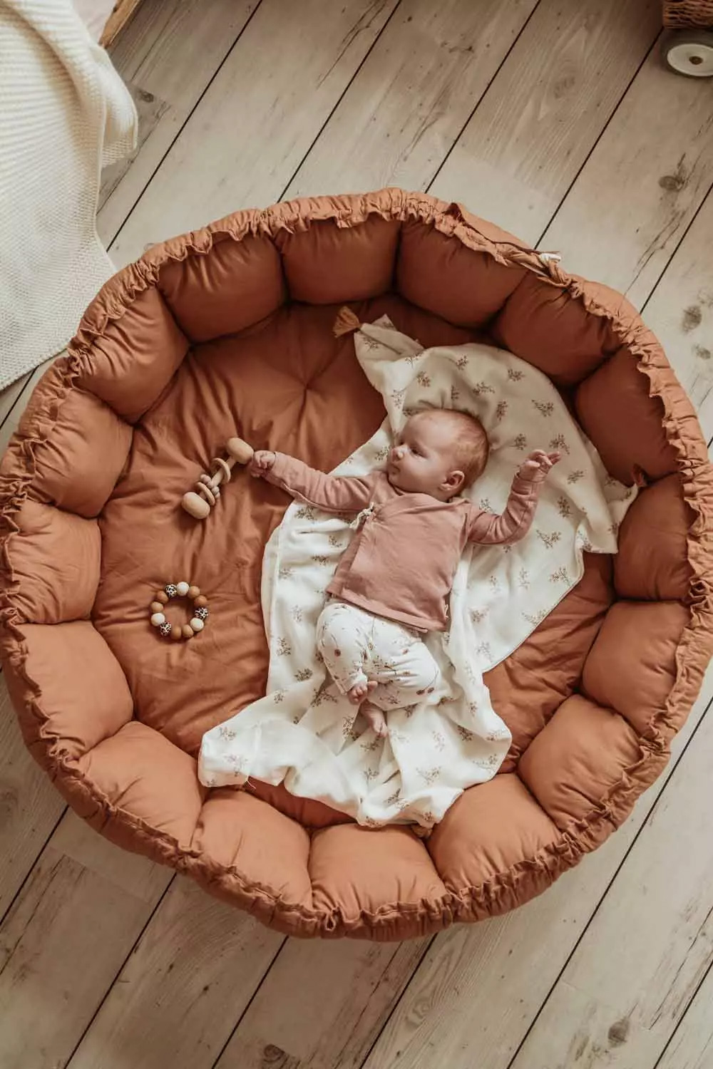 Bébé qui dort dans le tapis d'éveil Bloom marron aux bords relevés