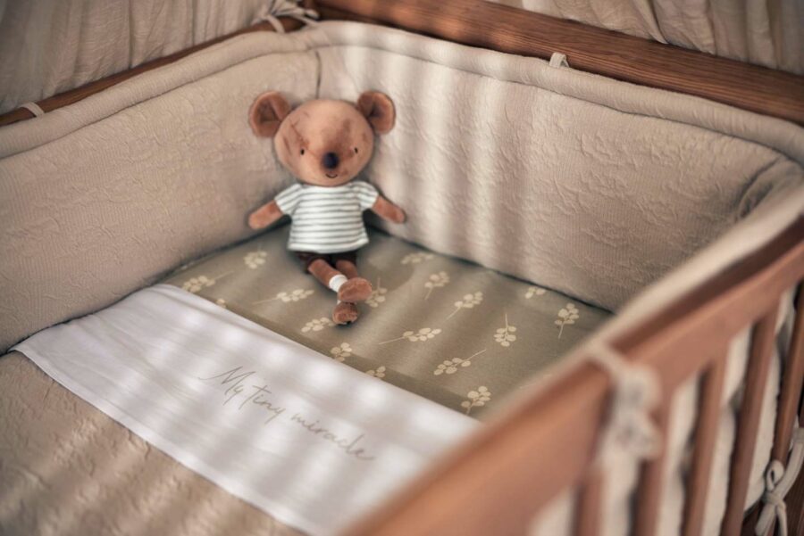 Peluche mouse Jackie dans un lit pour enfant